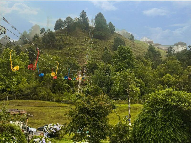 Teleférico de cadeiras suspensas em meio à vegetação